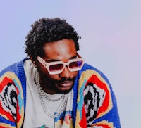 a man wearing sunglasses and a colorful sweater