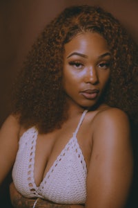 a black woman in a white bikini posing for a photo