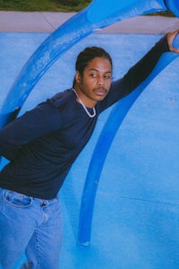 a man leaning on a blue playground structure